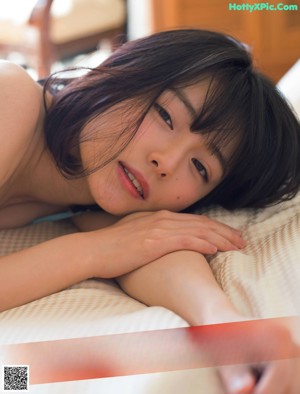 A woman laying on the floor next to a book.