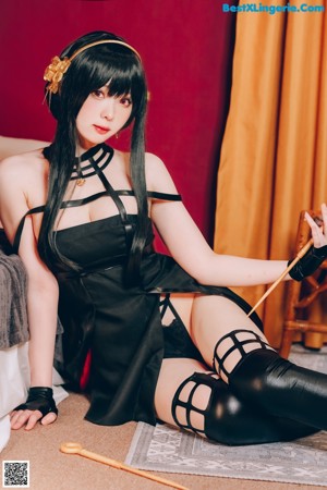 A woman in a black dress holding a sword.
