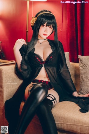 A woman in a black dress sitting on the floor.