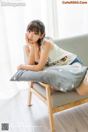 A woman laying on a couch with a pillow.
