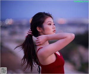 A woman in a pink bikini standing in the dark.