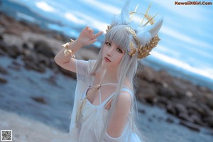 A woman in a white dress standing on a bridge.