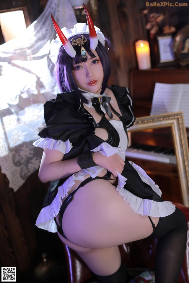 A woman dressed as a maid sitting on a chair.