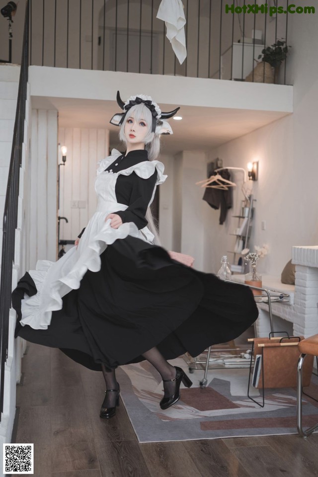 A woman in a black and white dress is posing for a picture.