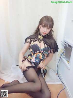 A woman in a black dress and black tights posing for the camera.