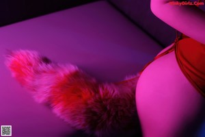 A woman in a black lingerie laying on a fur rug.