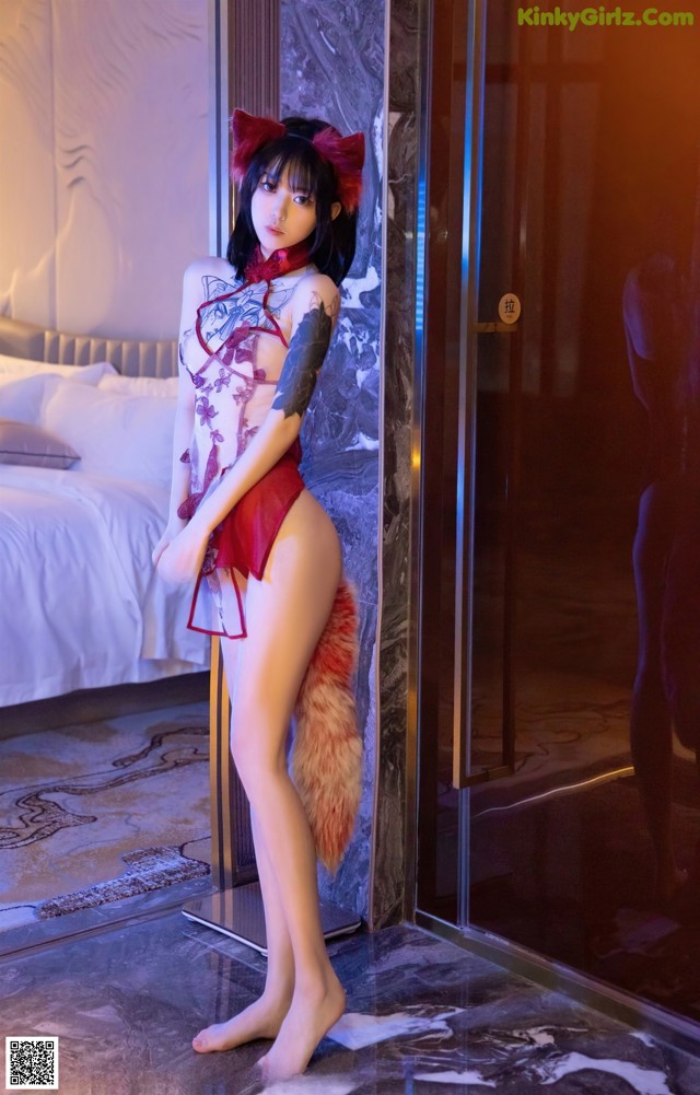 A woman in a red lingerie posing in front of a mirror.