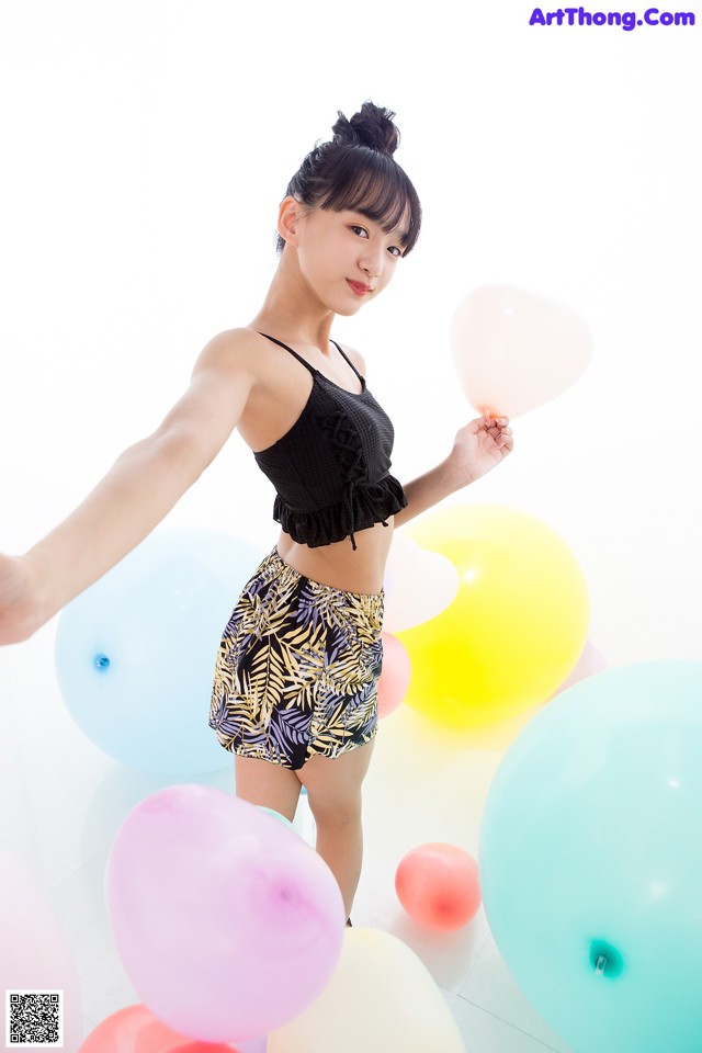 A woman standing in front of a bunch of balloons.