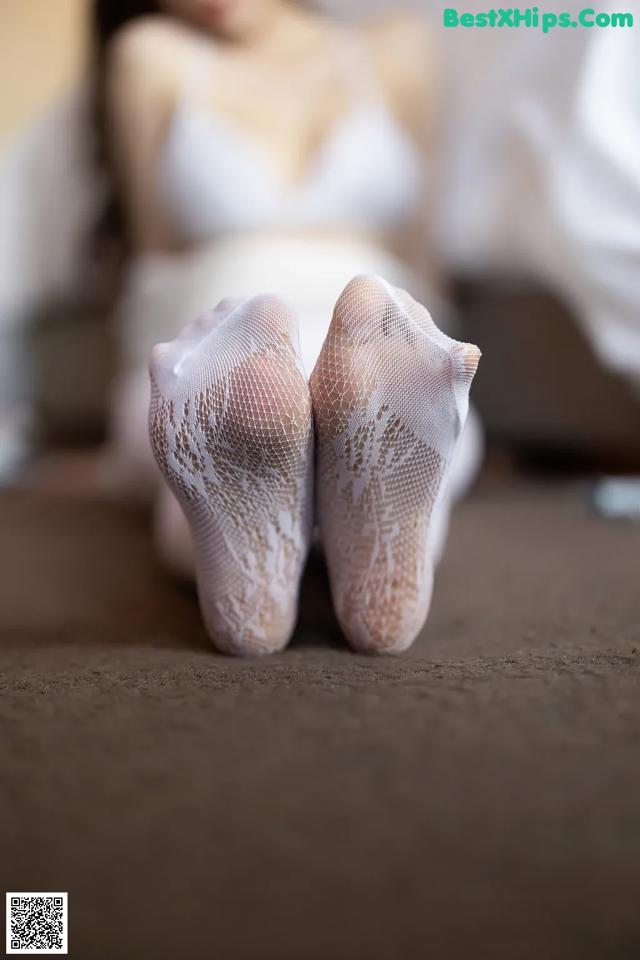 A woman laying on the floor with her feet up in white socks.