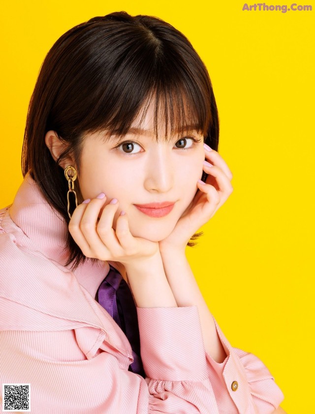 A woman in a pink shirt and purple tie posing for a picture.