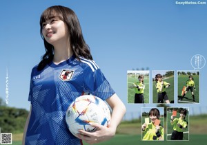 A woman in a blue shirt holding a soccer ball.