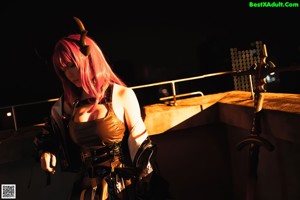 A woman with red hair and horns sitting on a chair.