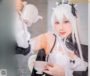 A woman dressed in a maid outfit holding a cup of coffee.