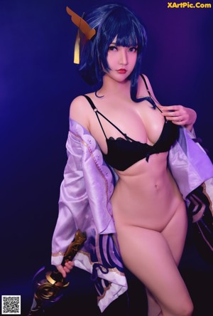 A woman with long blue hair is posing for a picture.