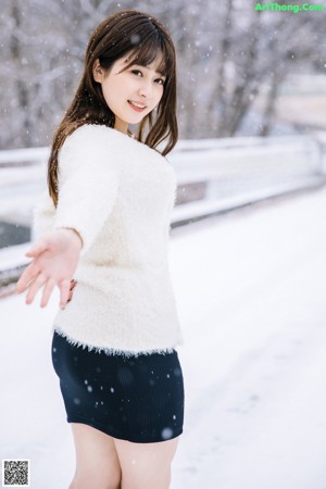 A naked asian woman standing in the snow.