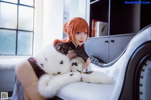 A woman sitting on a white couch in a room.