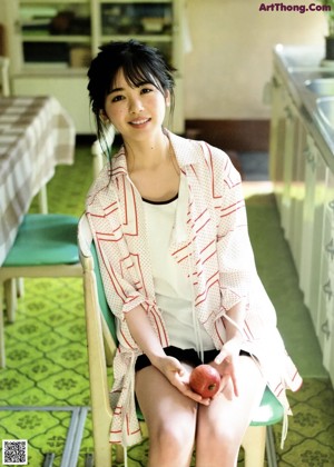 A woman in a red blouse poses for a picture.