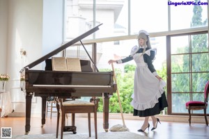 A woman in a maid outfit sitting at a piano.