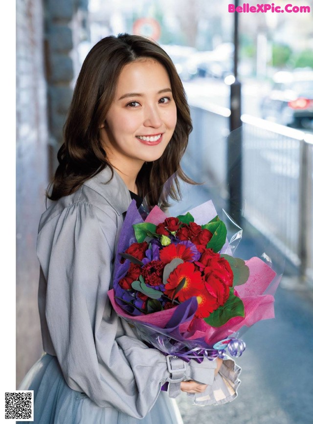 A woman holding a bunch of flowers in her hands.