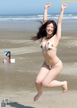 A woman in a yellow bikini sitting on the floor.