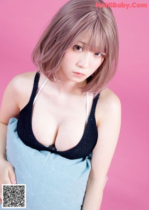 A woman with pink hair and a white tank top.