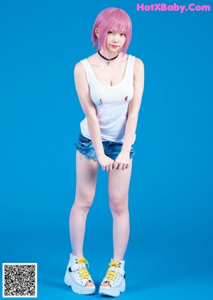 A woman in a black top and pink shorts posing for a magazine.