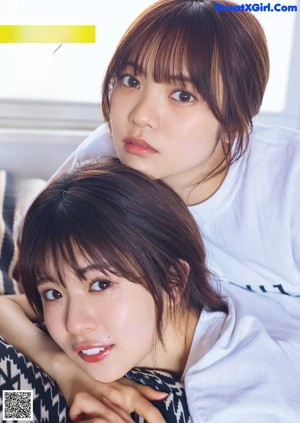 Two women sitting on a couch in a clothing store.