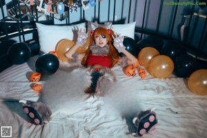 A woman in a cat costume sitting on a bed.