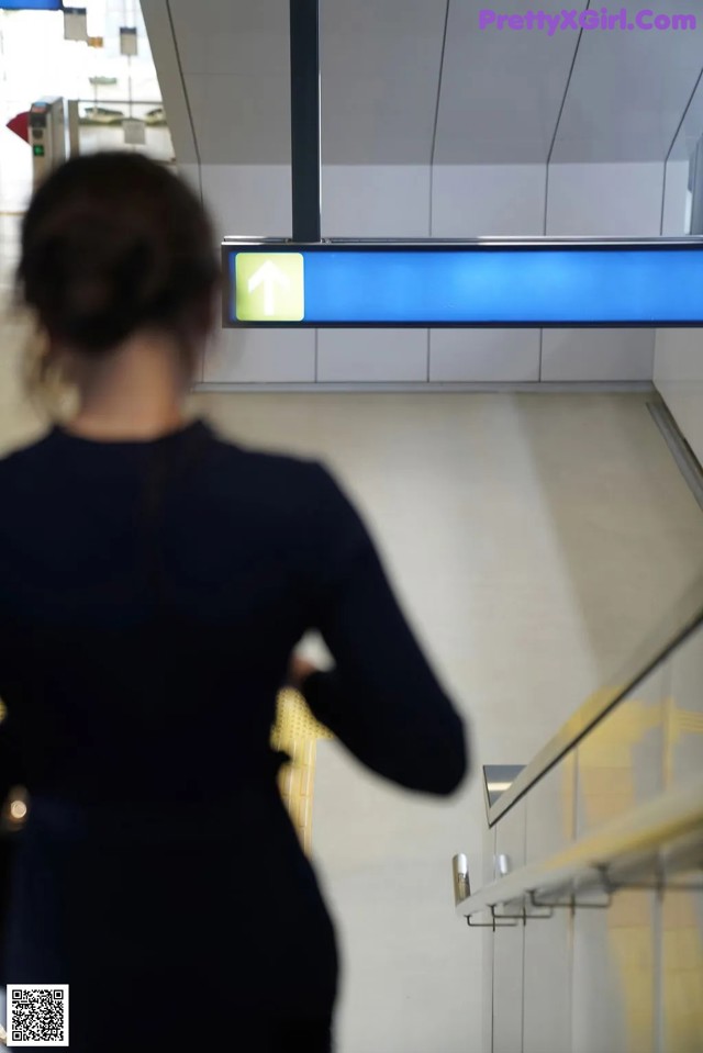 A woman walking down an escalator in an airport.