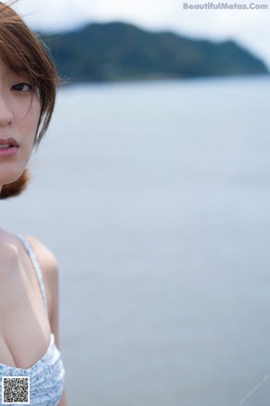 A woman in a bikini sitting on the beach.