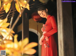 A woman in a purple lingerie posing by a window.