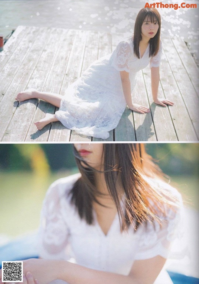 A woman in a white dress sitting on a wooden dock.