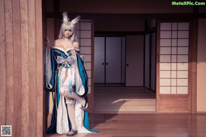 A woman with long white hair sitting on the floor.