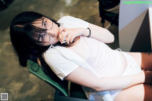 A woman sitting in a chair with a pen in her hand.